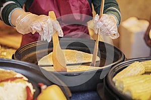 Hands of cook in gloves and apron close-up. Process of preparing quesadilla, burrito, fajitas. Authentic street food