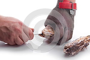 Hands of the cook opening an oyster