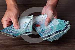 Hands counting money of ringgit Malaysia 50