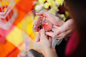 Hands of a couple and a candle