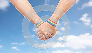 Hands of couple with gay pride rainbow wristbands