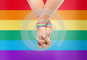 Hands of couple with gay pride rainbow wristbands