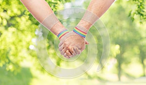 Hands of couple with gay pride rainbow wristbands
