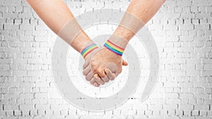 Hands of couple with gay pride rainbow wristbands