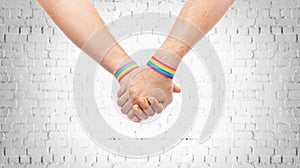 Hands of couple with gay pride rainbow wristbands photo