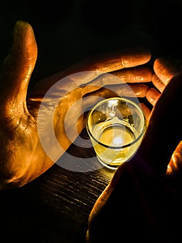 Hands Covering Candle at Glass