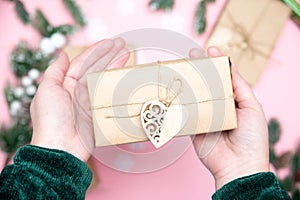 Hands with craft gifts on pink background flatlay