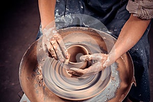 Hands of crafts-artist making craft, pottery, sculptor from fresh wet clay on pottery wheel, Modeling of pottery on the