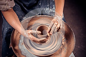 Hands of crafts-artist making craft, pottery, sculptor from fresh wet clay on pottery wheel, Modeling of pottery on
