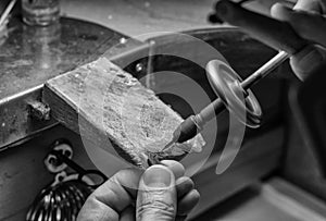 Hands of a craftsman jeweler working on jewelry. Goldsmith. Jewelry and valuables workshop. Goldsmith Hand Drill.