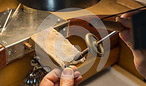 Hands of a craftsman jeweler working on jewelry. Goldsmith. Jewelry and valuables workshop. Goldsmith Hand Drill.