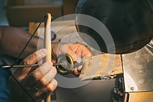 Hands of a craftsman jeweler working on jewelry. Goldsmith. Jewelry and valuables workshop. Goldsmith Hand Drill.