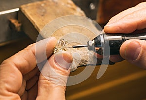 Hands of a craftsman jeweler working on jewelry. Goldsmith. Jewelry and valuables workshop. Goldsmith Hand Drill.