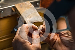 Hands of a craftsman jeweler working on jewelry. Goldsmith. Jewelry and valuables workshop. Goldsmith Hand Drill.