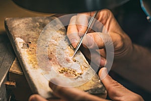 Hands of a craftsman jeweler working on jewelry. Goldsmith. Jewelry and valuables workshop. Goldsmith Hand Drill.