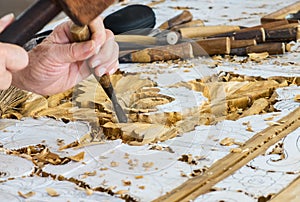 Hands of the Craftsman Working on Wooden Carving in Vintage Floral Pattern