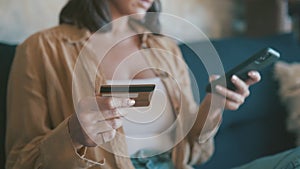 Hands, credit card and phone for home online shopping, e commerce and fintech payment on sofa. Woman typing on her