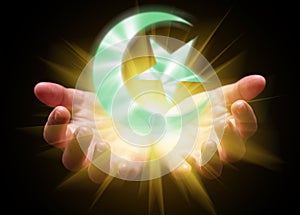 Hands cupped and holding or showing the Islamic Crescent Moon and Star