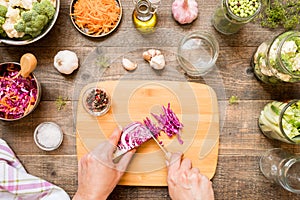 Hands cut cabbage for canning and other canning vegetables. Food preservation and conservation concept