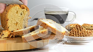 Hands cut cake with raisin on a chopping board a sharp knife