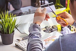 Hands cutting credit card with scissors