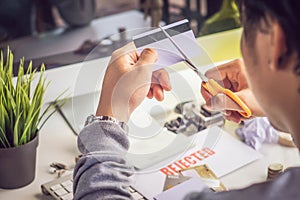 Hands cutting credit card with scissors