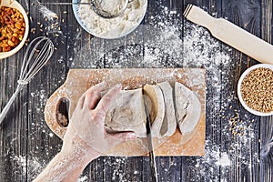 Hands cutting dough. Preparation recipe bread, pizza or pie making ingridients, food flat lay on kitchen table background