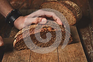 Hands cutting rye bread