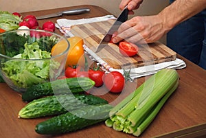 Hands cutting vegetables on kitchen table