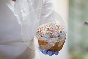 Hands decorate Easter bun.
