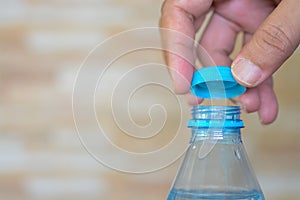 hands delicately twist open the cap of a refreshing bottle of water, ready to quench a thirst