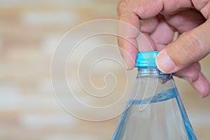 hands delicately twist open the cap of a refreshing bottle of water, ready to quench a thirst