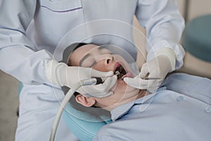 Hands of dentist holding a dental tool. Checking the teeth to th