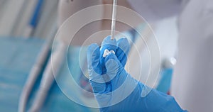 hands of a dentist in medical gloves work with dental implants and crowns in a medical office