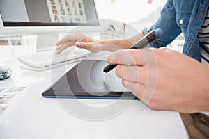 Hands of designer typing on keyboard and using digitizer