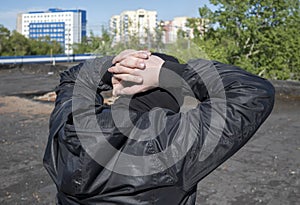 The hands of the detained bandit are closed behind the head