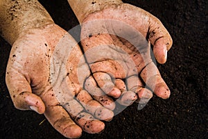 Hands dirty with clay , soil background