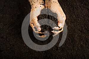 Hands dirty with clay , soil background