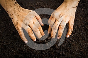 Hands dirty with clay , soil background