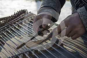 Hands dirty old street musician played on an old musical instrument