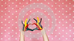 Hands dirty painted colorful show heart. The concept of happiness,love, art, creative, good mood and joy.