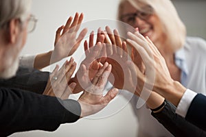 Hands of diverse business people giving high five, close up