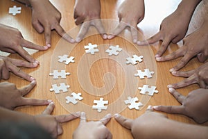 Hands of diverse people assembling jigsaw puzzle, team put pieces together searching for right match, help support in teamwork to