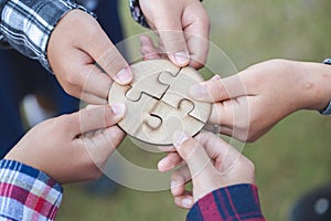 Hands of diverse people assembling jigsaw puzzle, team put pieces together searching for right match, help support in teamwork to