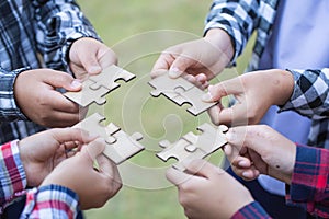 Hands of diverse people assembling jigsaw puzzle, team put pieces together searching for right match, help support in teamwork to