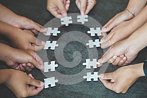 Hands of diverse people assembling jigsaw puzzle, team put pieces together searching for right match, help support in teamwork to