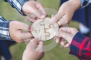 Hands of diverse people assembling jigsaw puzzle, team put pieces together searching for right match, help support in teamwork to