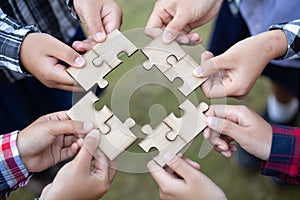 Hands of diverse people assembling jigsaw puzzle, team put pieces together searching for right match, help support in teamwork to