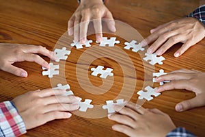 Hands of diverse people assembling jigsaw puzzle, Youth team put