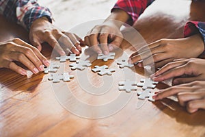 Hands of diverse people assembling jigsaw puzzle, Youth team put